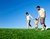 Børnefamilie går tur på græsplæne
