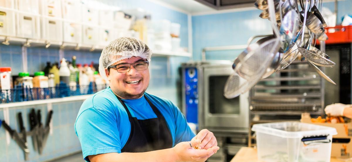 Køkkenmedarbejde smiler i køkken