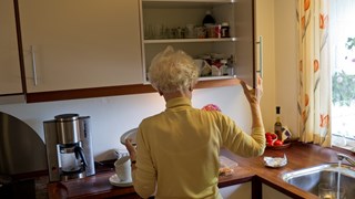 Ældre dame laver kaffe i sit køkken
