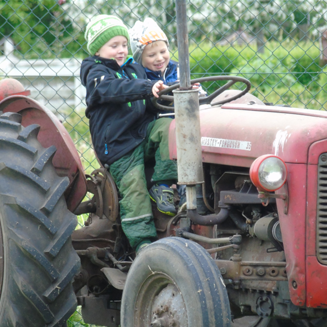 Børn leger på gammel traktor
