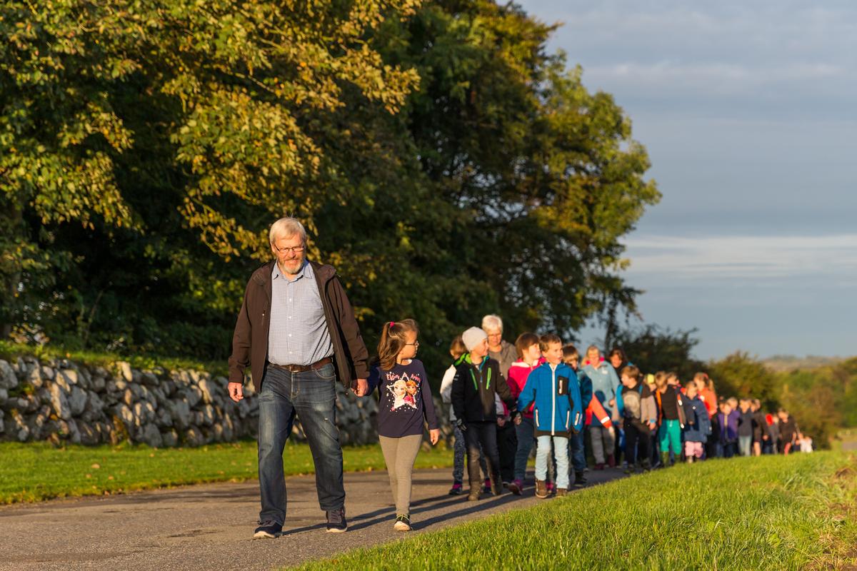 Lang række med børn og pædagoger går tur