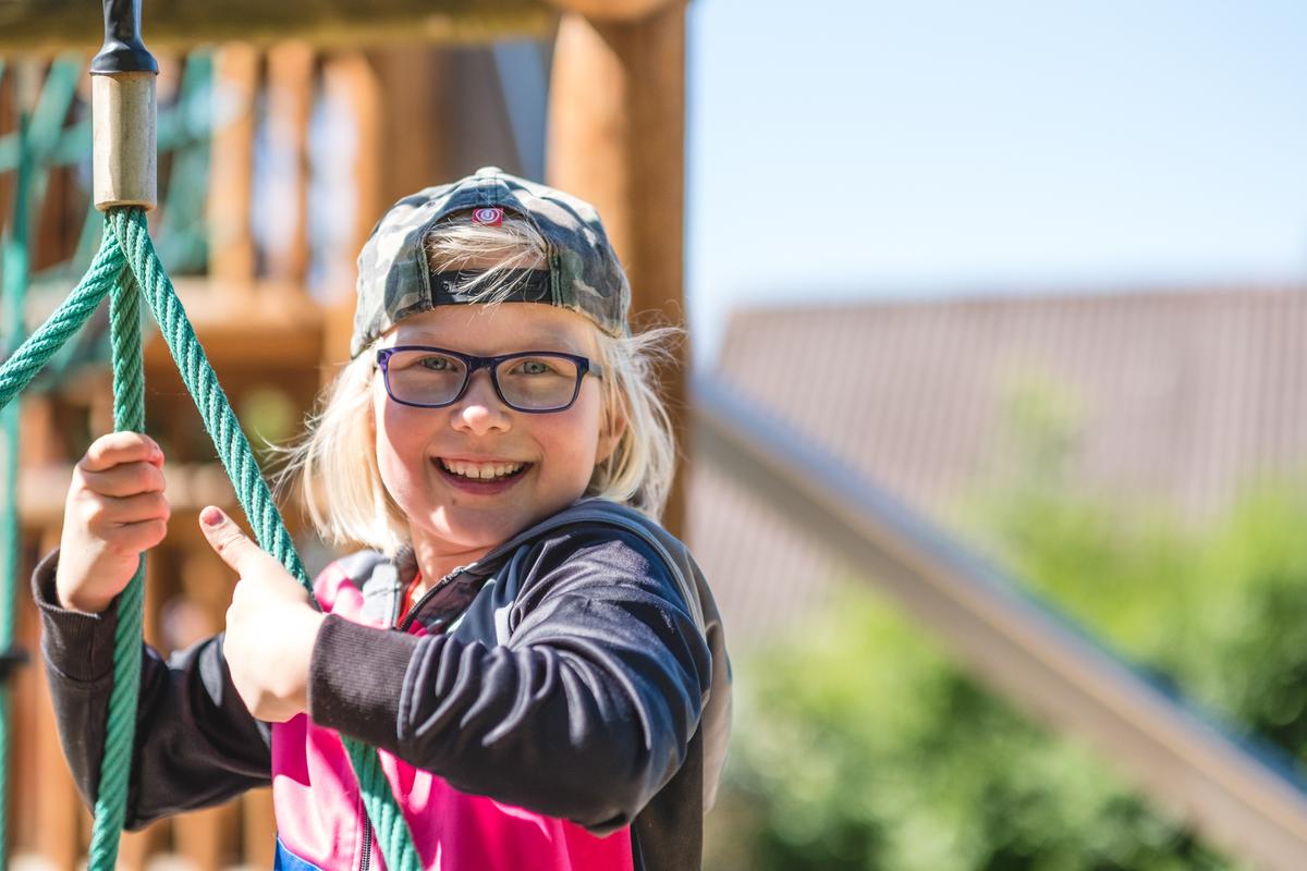 Barn holder fast i tov på legeplads