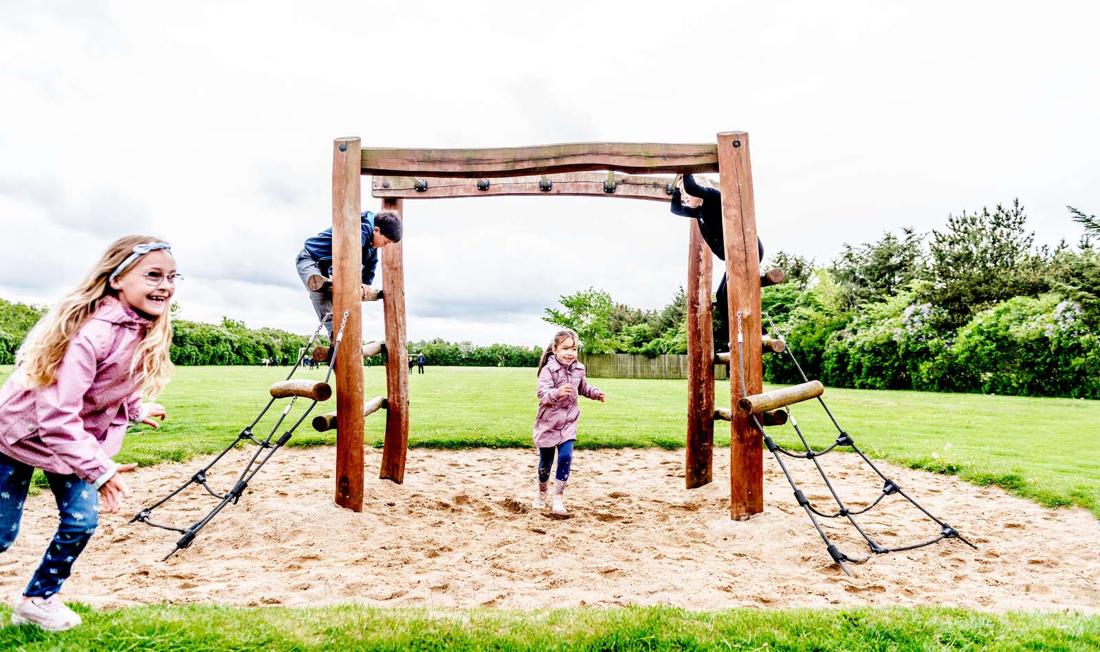 Børn klatrer og leger på legeplads