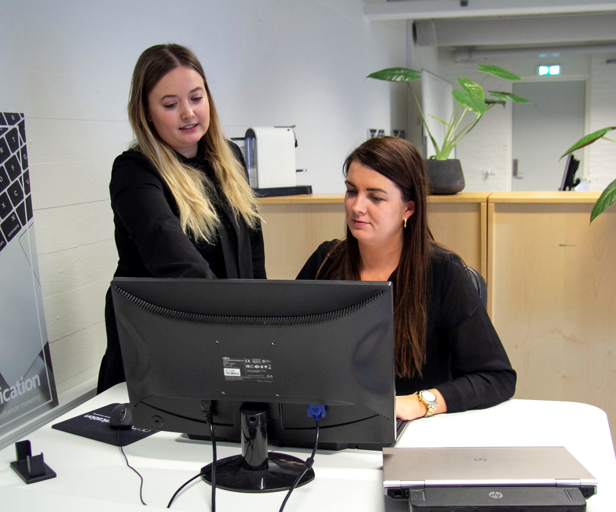 Kollegaer diskuterer noget på skærmen