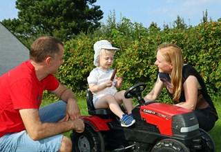 Familie med barn på pedaltraktor