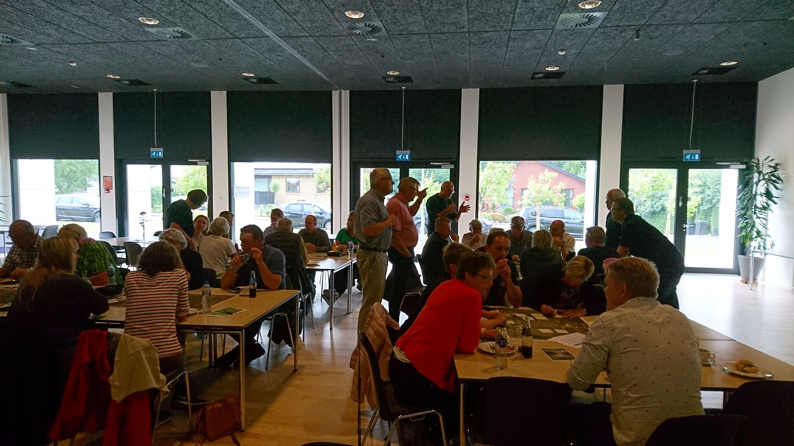 Personer sidder ved borde og taler