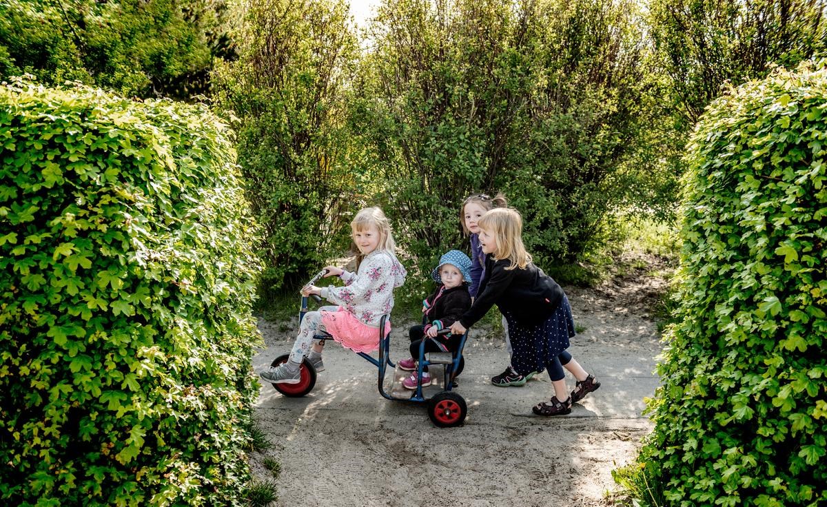 Børn på hyggelige tur på trehjulet pedalcykel