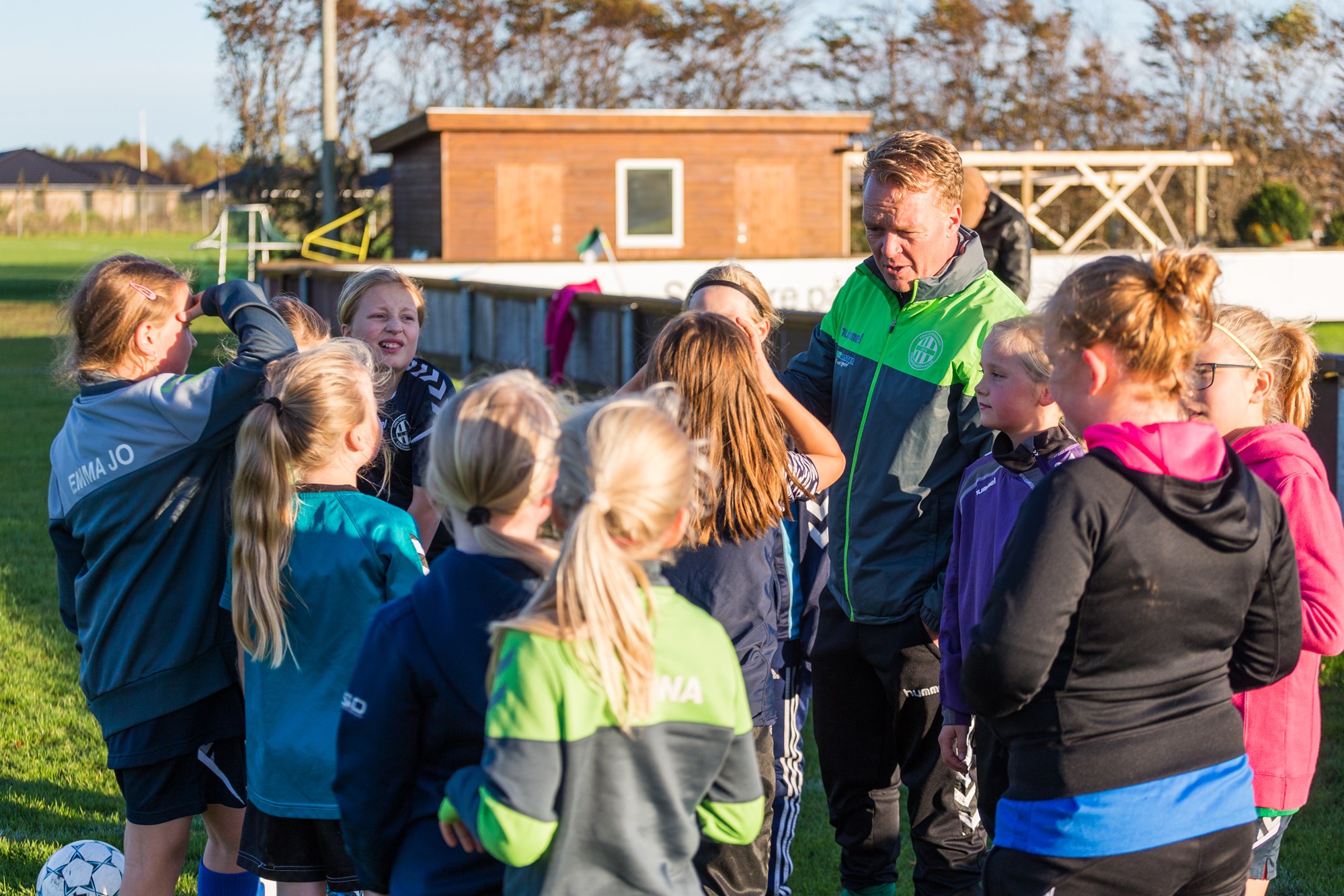 En flok fodboldpiger og deres træner