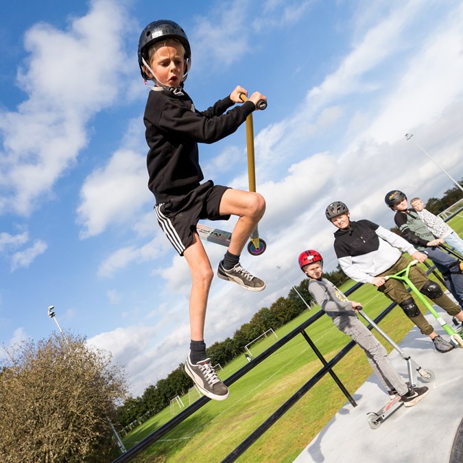 Dreng kører løbehjul på skateboard-bane