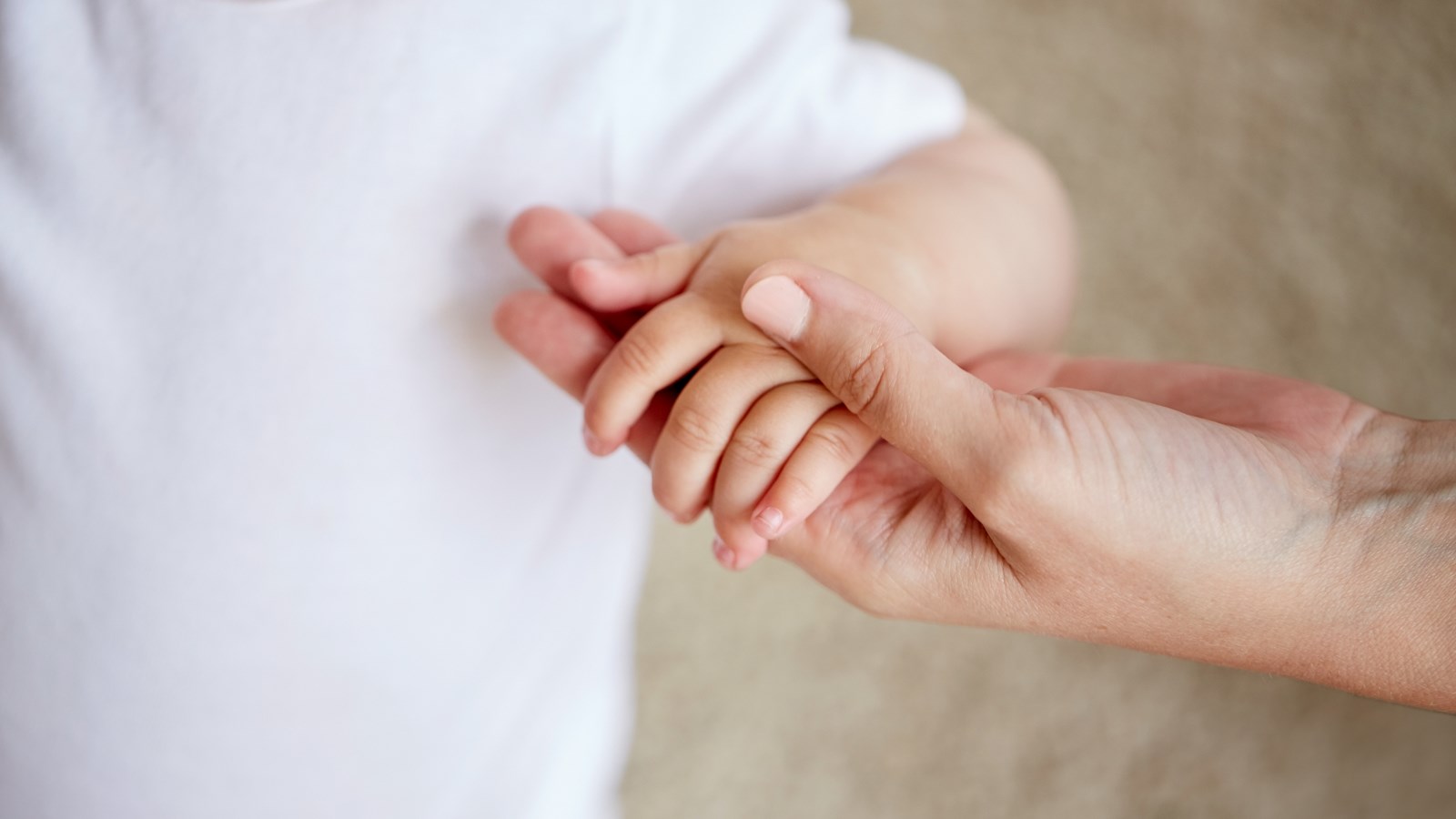 Voksen holder barn i hånden
