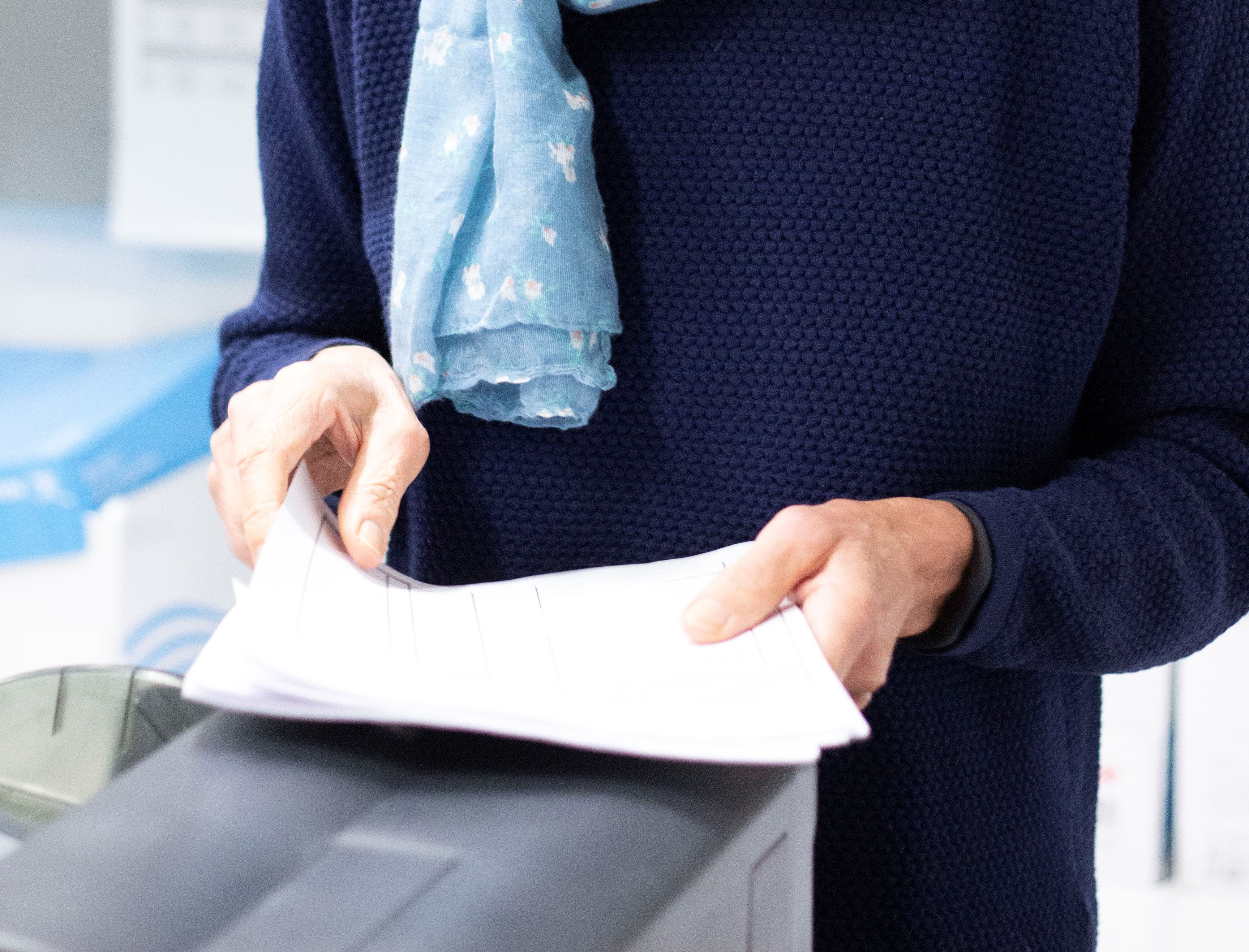 Person står med papirer i et kopirum