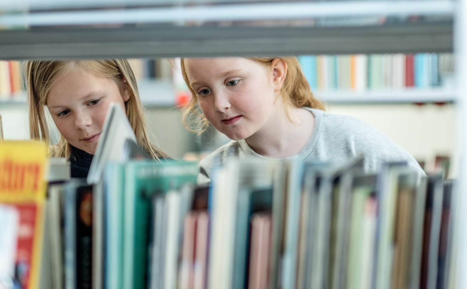 Elever bladrer på biblioteket