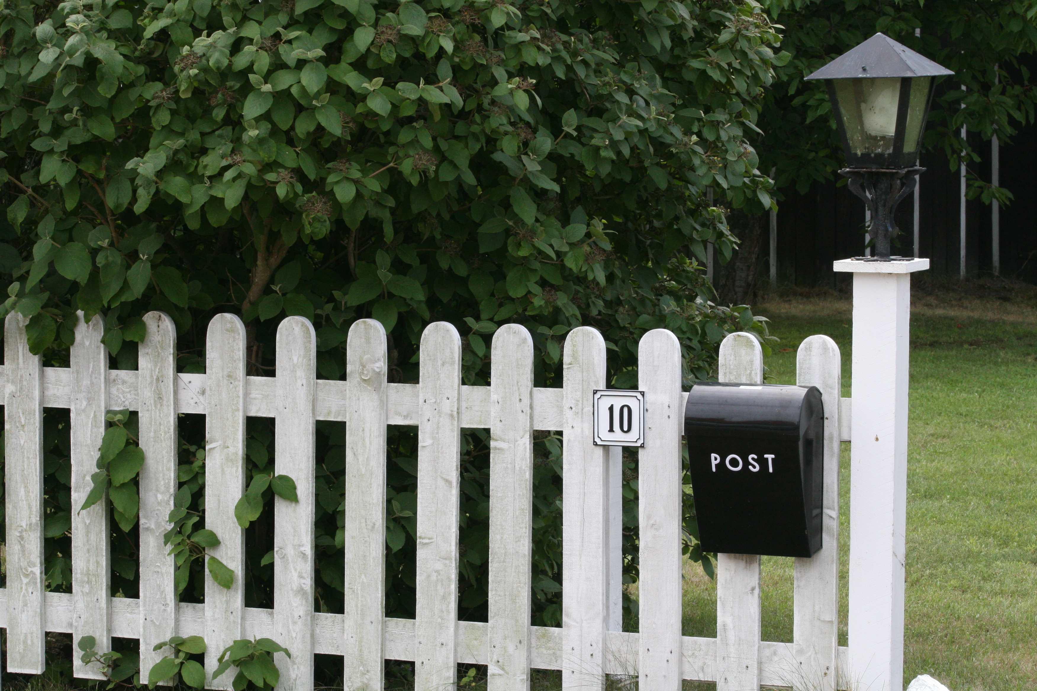 Hegn med postkasse og husnummer