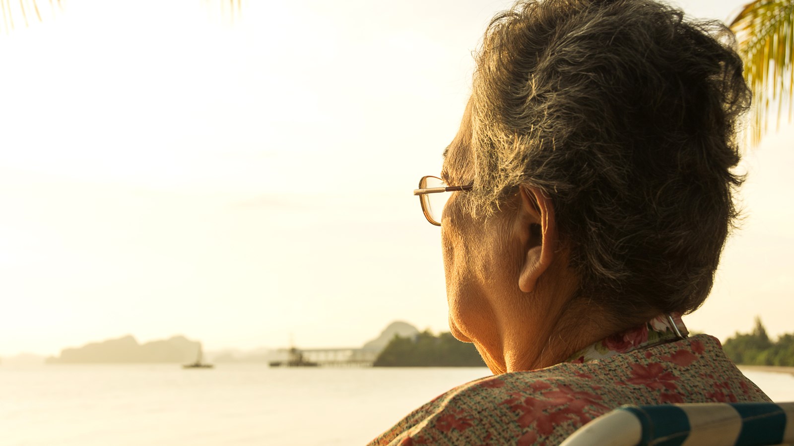 Ældre kvinde ser eftertænksomt ud i horisonten