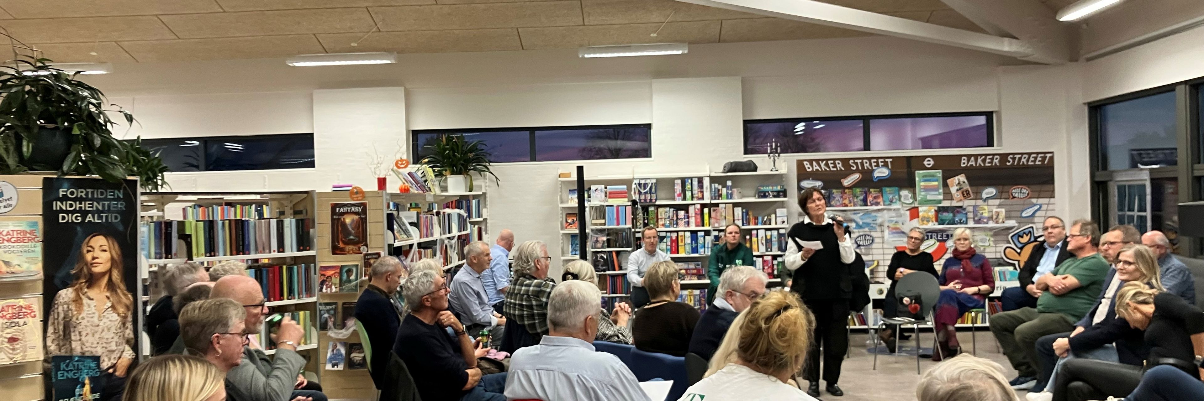 Foredragsholder og publikum på bibliotek