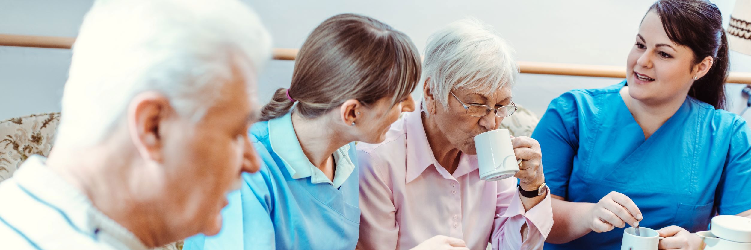 ældre og hjælpere drikker kaffe