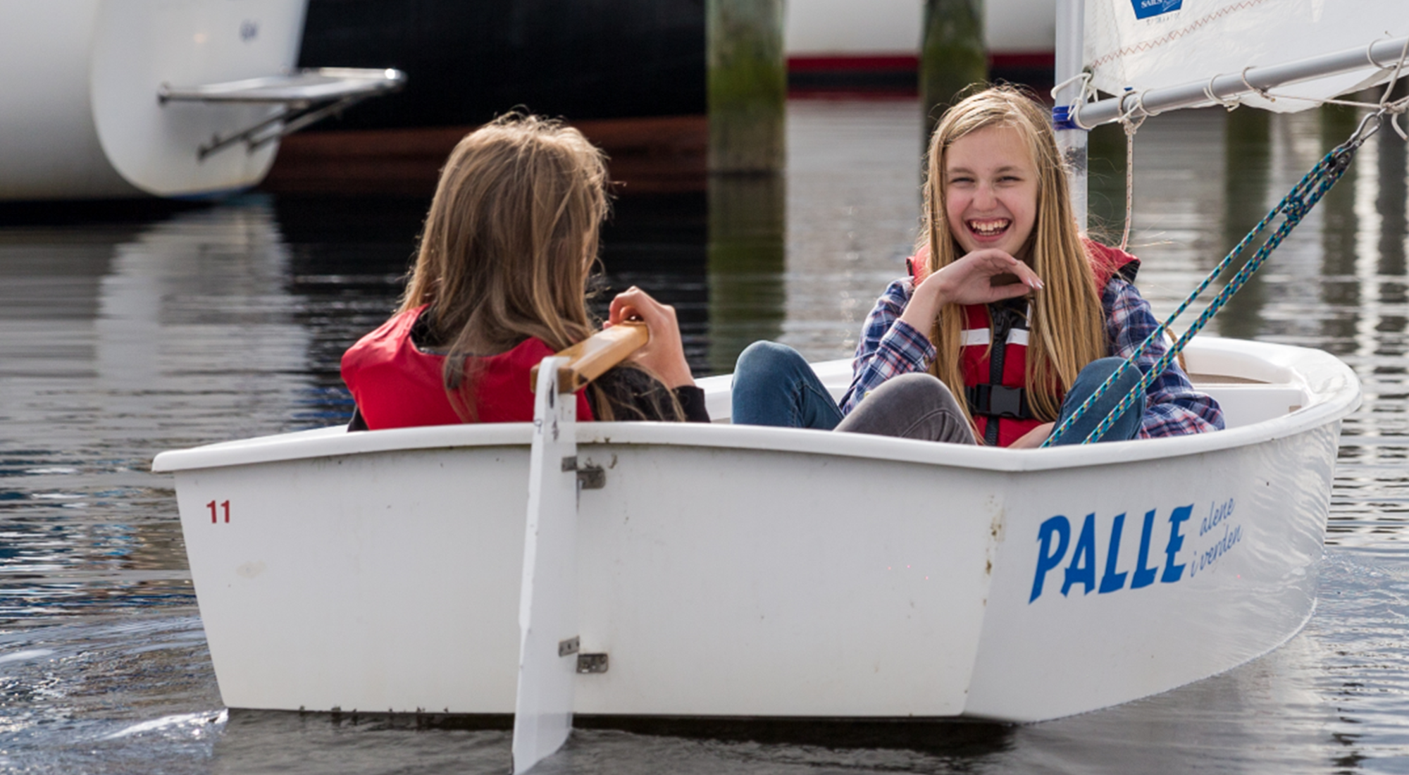 To piger sejler i lille båd