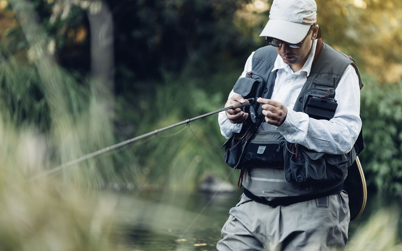 Lystfisker i waders og med fiskestang