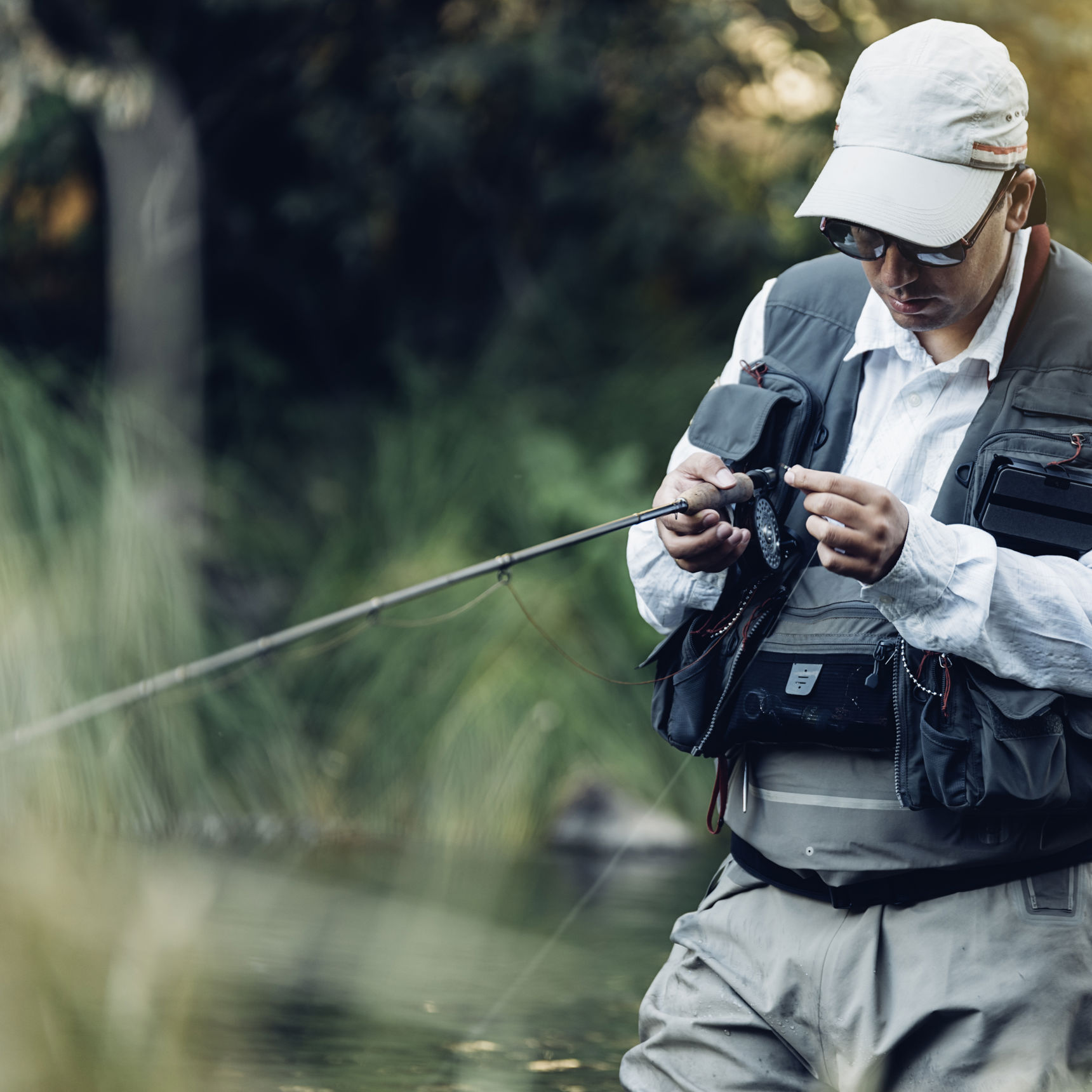 Lystfisker i waders og med fiskestang