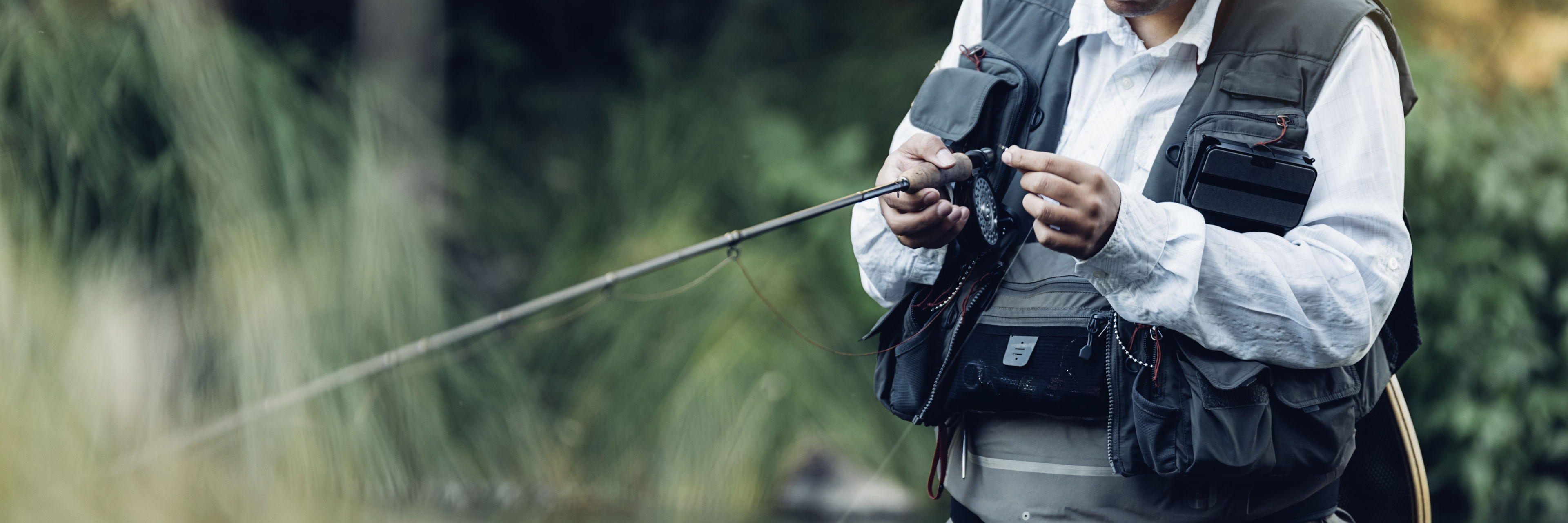 Lystfisker i waders og med fiskestang