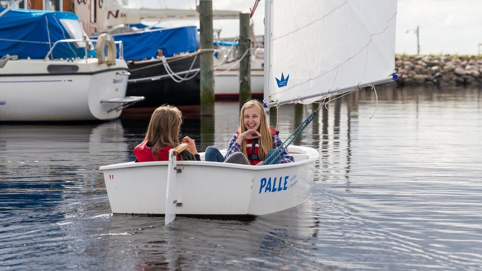 To piger sejler i lille båd