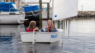 To piger sejler i lille båd