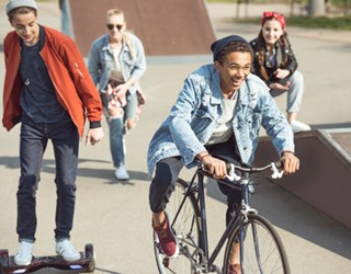 Unge mennesker cykler, skater og løber